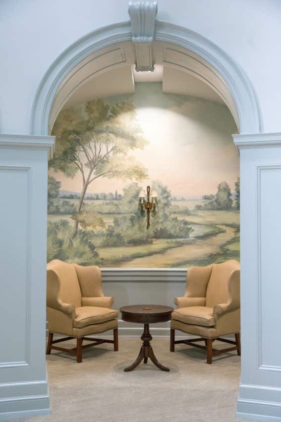 Sitting alcove with yellow chairs and scenic mural wallpaper