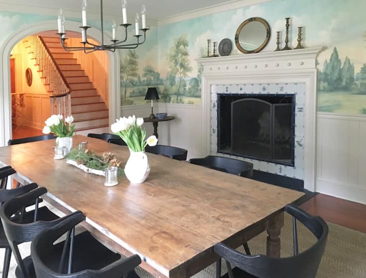 Dining room with scenic mural wallpaper around fireplace
