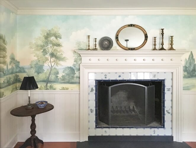 Antique fireplace with scenic mural wallpaper