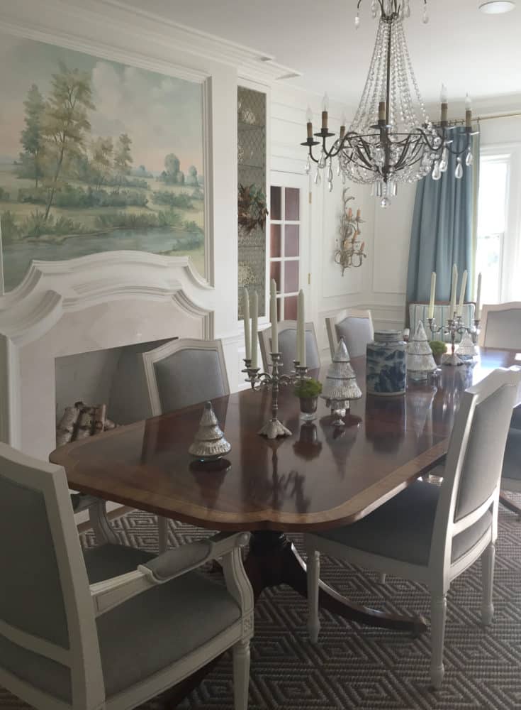Dining room with scenic mural wallpaper above fireplace