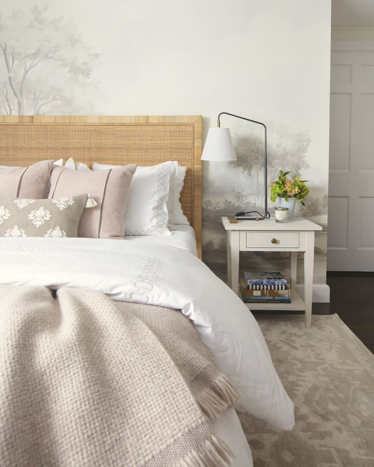 elegant grisaille mural wallpaper behind caned bed frame and modern, feminine bedroom decor