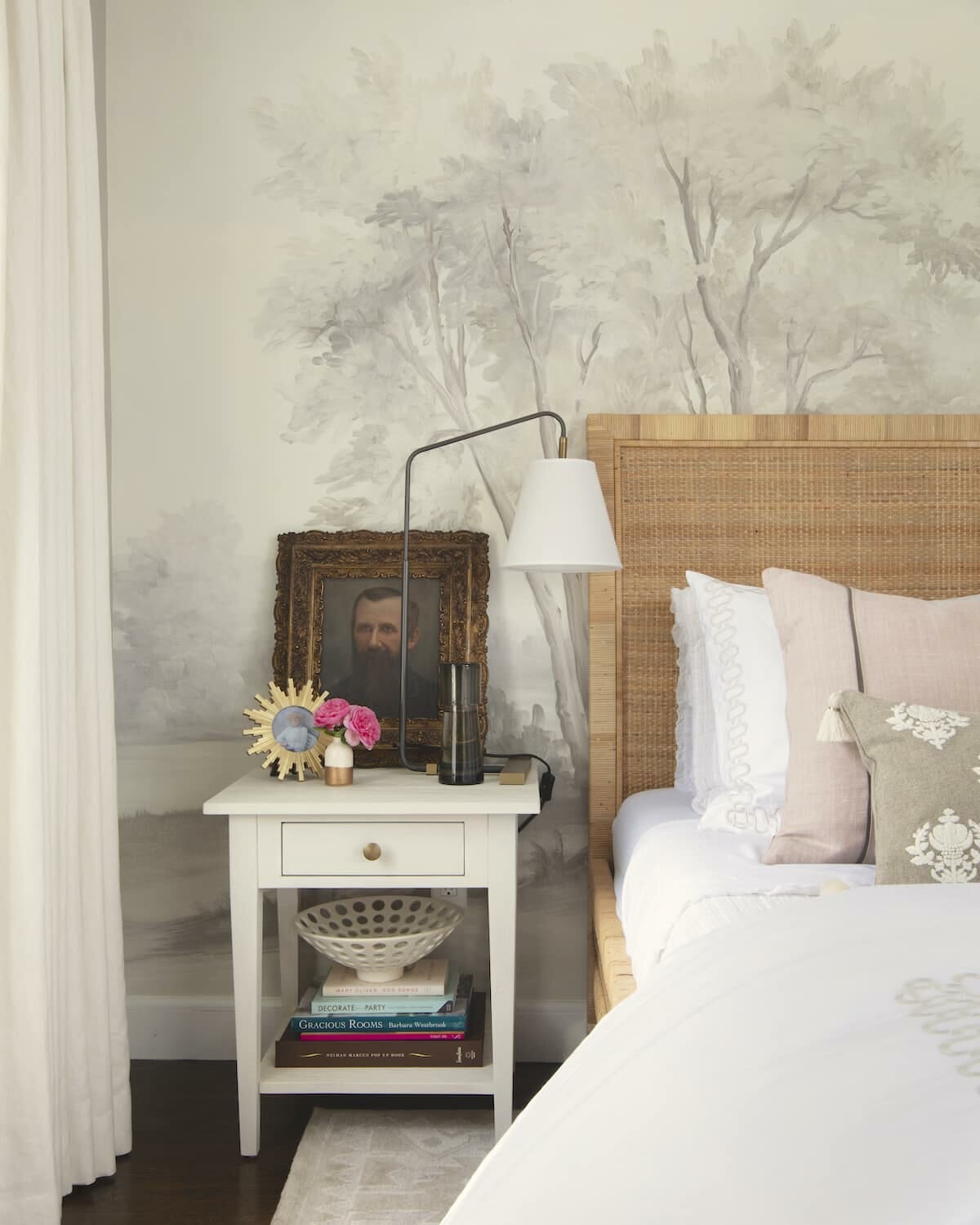 elegant grisaille mural wallpaper behind caned bed frame and eclectic bedroom decor