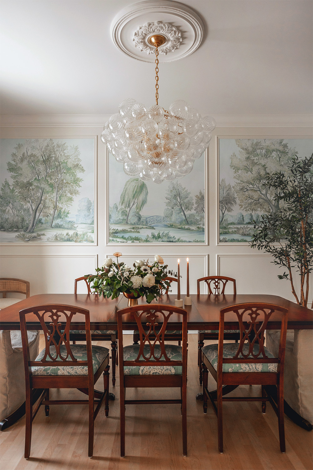 Blue painted scenic landscape wallpaper panels framed by mouldings in elegant dining room